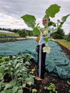 light skin black farmer holding a freshly harvested kohlrabi